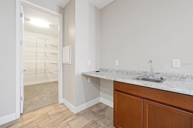 3844 Bowfin Trl, Kissimmee, FL 34746 - bar featuring a sink, light wood-type flooring, and baseboards