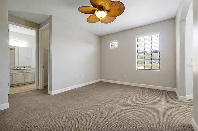 3844 Bowfin Trl, Kissimmee, FL 34746 - unfurnished room with light colored carpet, ceiling fan, baseboards, and a sink