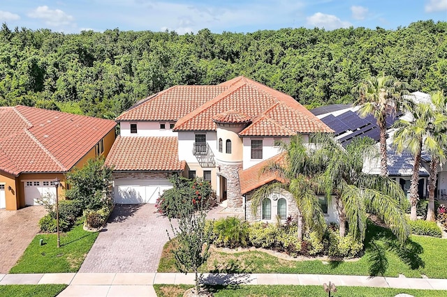 3844 Bowfin Trl, Kissimmee, FL 34746 - view of front facade featuring stone siding, a tile roof, stucco siding, a balcony, and driveway
