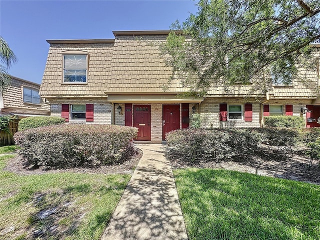 view of front of home featuring brick siding and mansard roof