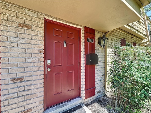 doorway to property with brick siding