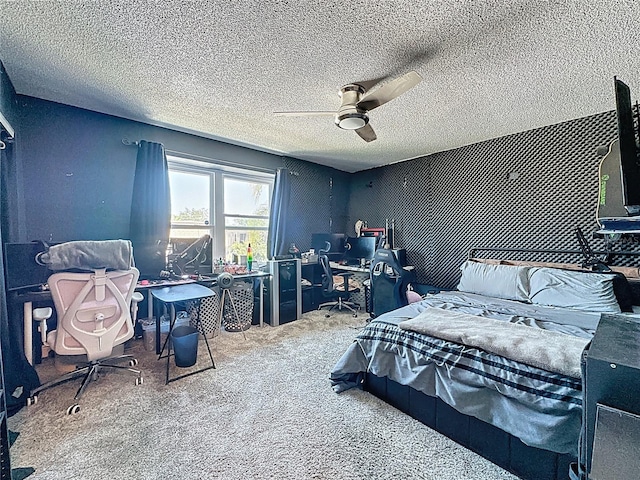 carpeted bedroom with an office area, ceiling fan, and a textured ceiling