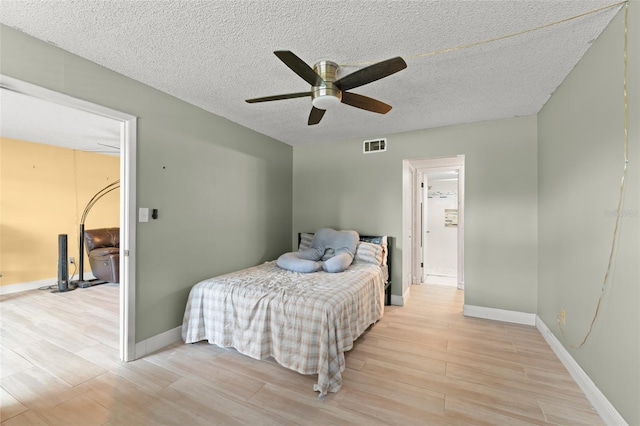 3475 Flossmoor Ave Unit 103, Orlando, FL 32822 - bedroom featuring light wood-style floors, baseboards, a textured ceiling, and ceiling fan