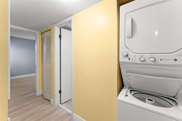 3475 Flossmoor Ave Unit 103, Orlando, FL 32822 - laundry area with stacked washer / dryer, light wood-type flooring, baseboards, and a textured ceiling
