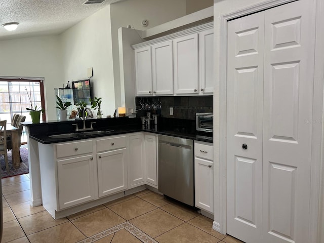 340 Haversham Way, Davenport, FL 33897 - kitchen with stainless steel dishwasher, a sink, a peninsula, white cabinets, and dark countertops