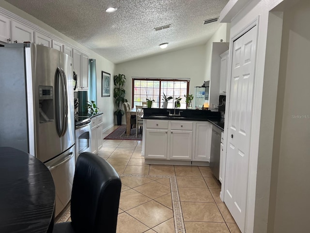 340 Haversham Way, Davenport, FL 33897 - kitchen featuring stainless steel appliances, light tile patterned flooring, a peninsula, a textured ceiling, and lofted ceiling