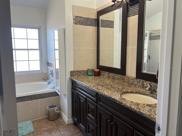 340 Haversham Way, Davenport, FL 33897 - bathroom featuring vanity, a relaxing tiled tub, and tile patterned flooring