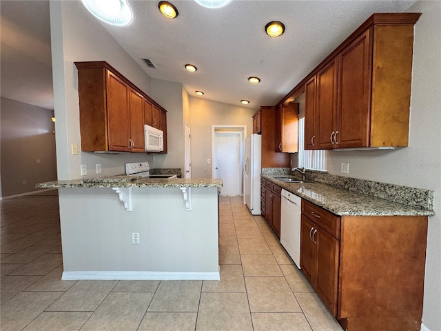 703 Tartan Loop, Lake Wales, FL 33853 - kitchen with white appliances, a peninsula, light tile patterned floors, a kitchen breakfast bar, and light stone countertops