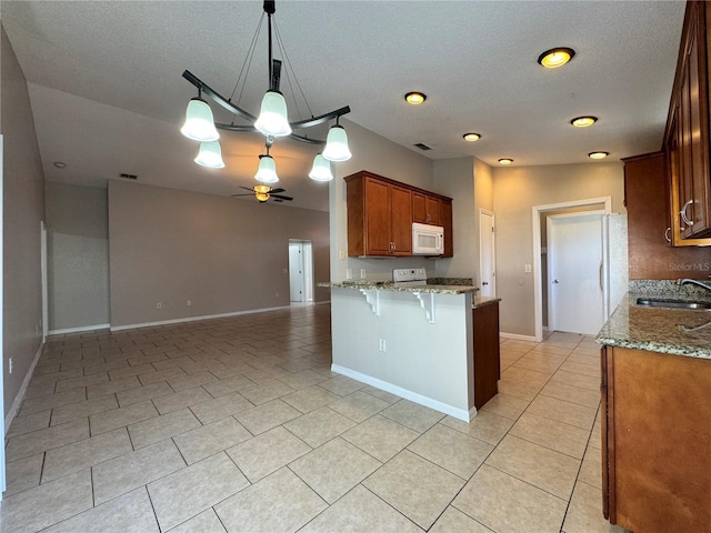 703 Tartan Loop, Lake Wales, FL 33853 - kitchen with white microwave, a sink, ceiling fan, light tile patterned floors, and light stone countertops