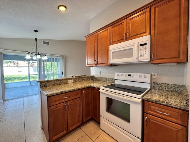 703 Tartan Loop, Lake Wales, FL 33853 - kitchen with white appliances, brown cabinetry, a peninsula, a textured ceiling, and a chandelier
