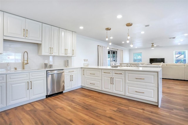 6700 Tamarind Cir, Orlando, FL 32819 - kitchen with stainless steel dishwasher, a sink, wood finished floors, white cabinetry, and ornamental molding