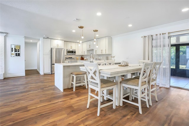 6700 Tamarind Cir, Orlando, FL 32819 - dining space with ornamental molding, dark wood finished floors, recessed lighting, and baseboards