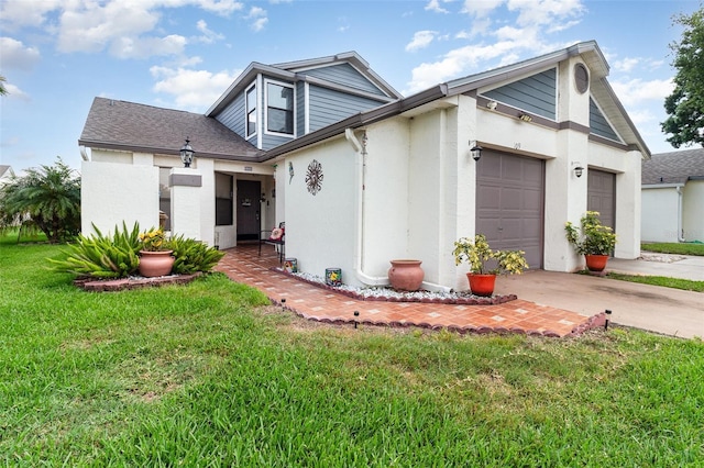 109 Lakepointe Cir, Kissimmee, FL 34743 - view of front facade with a garage, driveway, a front lawn, stucco siding, and roof with shingles