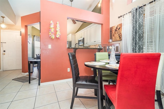 109 Lakepointe Cir, Kissimmee, FL 34743 - dining room featuring vaulted ceiling, light tile patterned floors, and baseboards