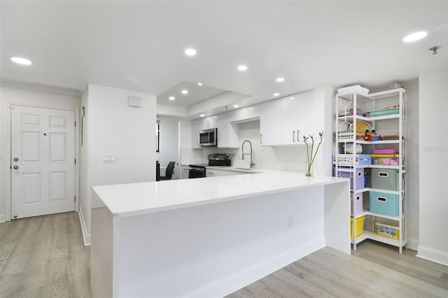 530 E Central Blvd Unit 803, Orlando, FL 32801 - kitchen featuring appliances with stainless steel finishes, light wood-style flooring, white cabinets, light countertops, and a sink