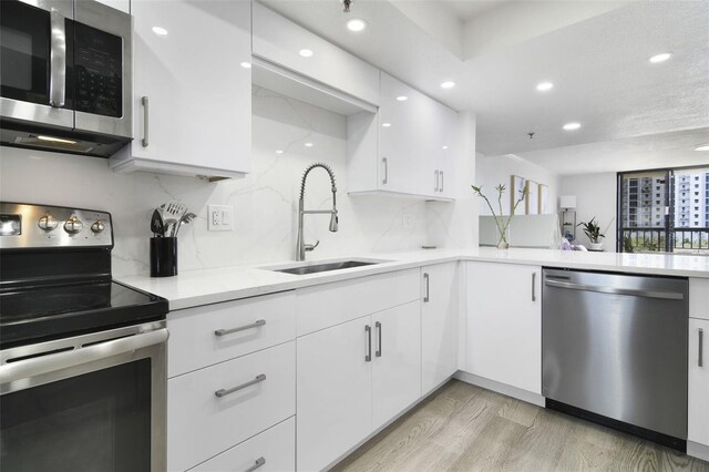 530 E Central Blvd Unit 803, Orlando, FL 32801 - kitchen featuring stainless steel appliances, a sink, recessed lighting, white cabinetry, and decorative backsplash