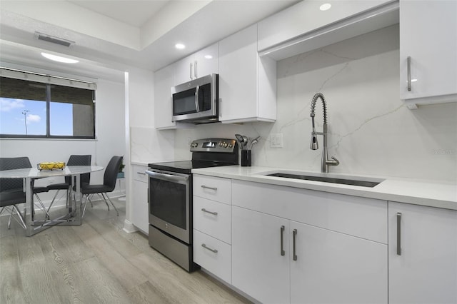 530 E Central Blvd Unit 803, Orlando, FL 32801 - kitchen featuring stainless steel appliances, a sink, light countertops, white cabinets, and recessed lighting