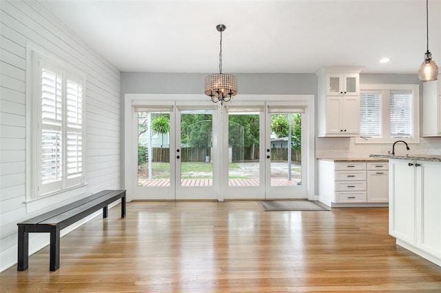 338 E Anderson St, Orlando, FL 32801 - unfurnished dining area with light wood-style floors, a chandelier, wooden walls, and recessed lighting
