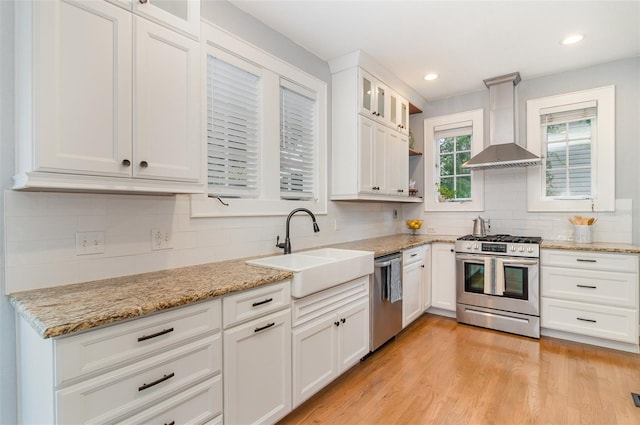338 E Anderson St, Orlando, FL 32801 - kitchen with stainless steel appliances, wall chimney exhaust hood, a sink, decorative backsplash, and recessed lighting