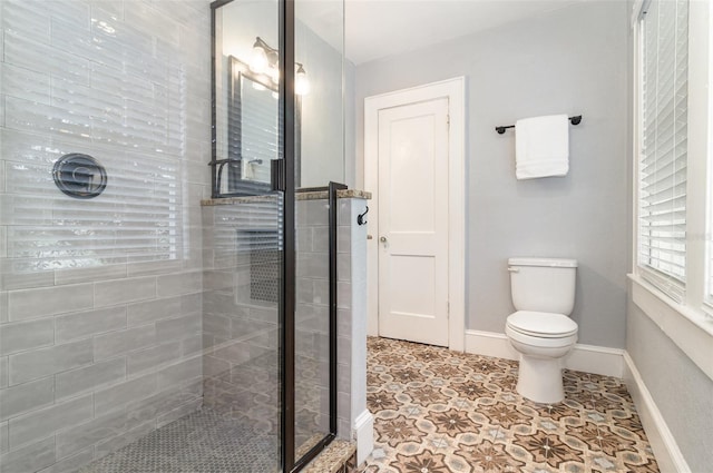 338 E Anderson St, Orlando, FL 32801 - bathroom with a shower stall, toilet, baseboards, and tile patterned flooring