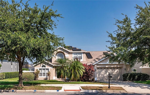 1201 Shelter Rock Rd, Orlando, FL 32835 - obstructed view of property featuring stucco siding, an attached garage, solar panels, and concrete driveway