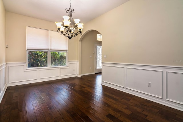 1201 Shelter Rock Rd, Orlando, FL 32835 - empty room with arched walkways, a chandelier, wainscoting, dark wood-style flooring, and a decorative wall