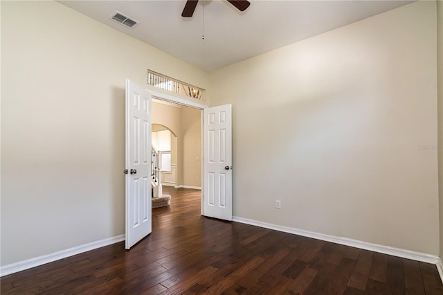 1201 Shelter Rock Rd, Orlando, FL 32835 - spare room featuring a ceiling fan, arched walkways, dark wood-style floors, and baseboards