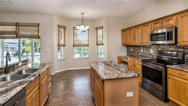 1201 Shelter Rock Rd, Orlando, FL 32835 - kitchen featuring stainless steel appliances, a sink, tasteful backsplash, a center island, and a chandelier