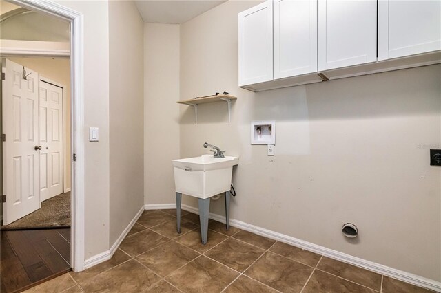 1201 Shelter Rock Rd, Orlando, FL 32835 - laundry room featuring cabinet space, hookup for a washing machine, baseboards, and dark tile patterned flooring