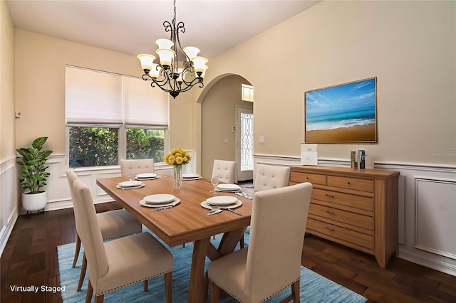 1201 Shelter Rock Rd, Orlando, FL 32835 - dining room with arched walkways, a wainscoted wall, dark wood finished floors, a decorative wall, and a chandelier