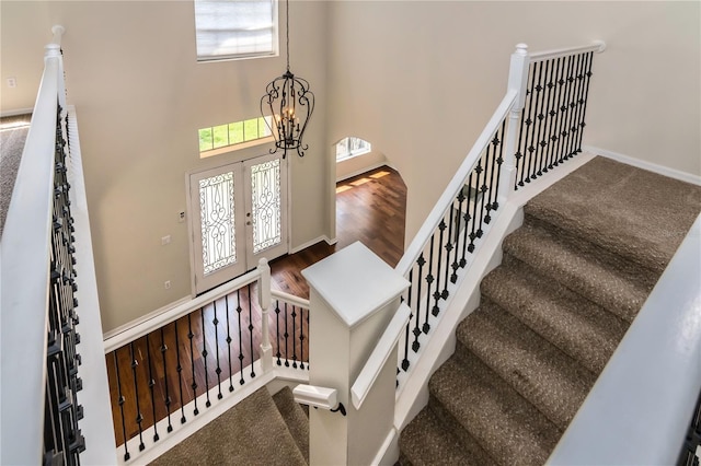 1201 Shelter Rock Rd, Orlando, FL 32835 - staircase featuring a chandelier, a high ceiling, and wood finished floors