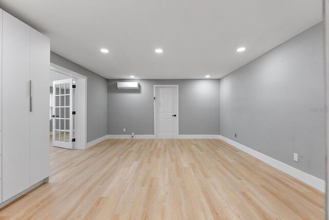 3926 Helena St NE, Saint Petersburg, FL 33703 - spare room with a wall unit AC, light wood-type flooring, recessed lighting, and baseboards