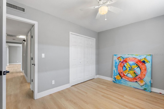 3926 Helena St NE, Saint Petersburg, FL 33703 - unfurnished bedroom with wood finished floors, baseboards, a closet, and a ceiling fan