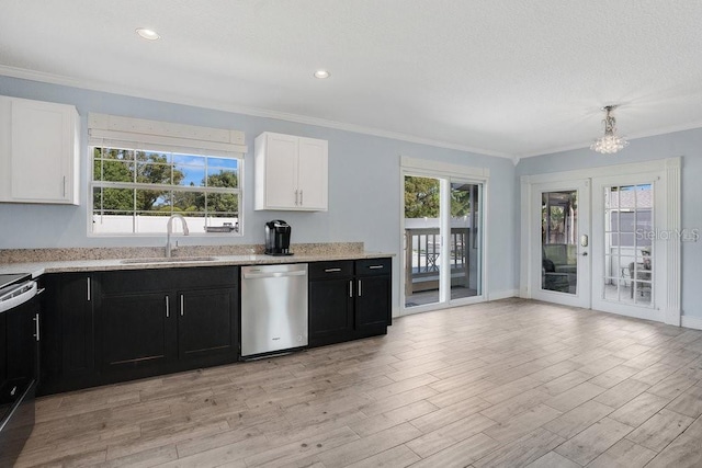 950 Gatewood Ct NE, Palm Bay, FL 32905 - kitchen featuring stainless steel appliances, a sink, dark cabinetry, ornamental molding, and white cabinetry