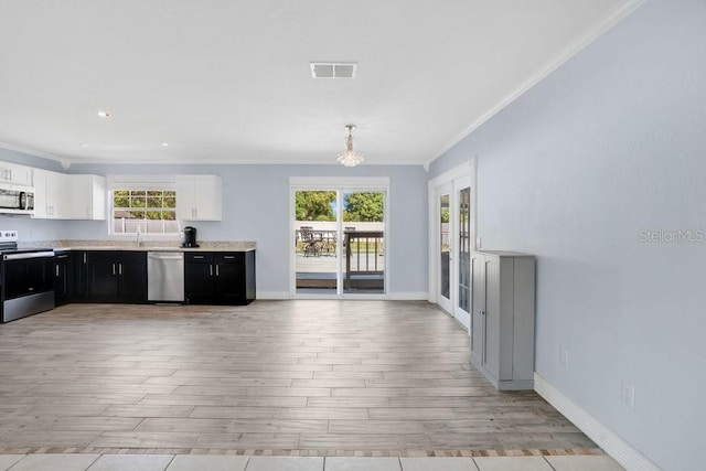 950 Gatewood Ct NE, Palm Bay, FL 32905 - kitchen featuring appliances with stainless steel finishes, crown molding, light wood-style flooring, light countertops, and dark cabinets