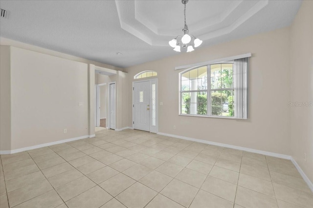45 Powder Horn Dr, Palm Coast, FL 32164 - empty room featuring a chandelier, light tile patterned floors, a raised ceiling, and baseboards