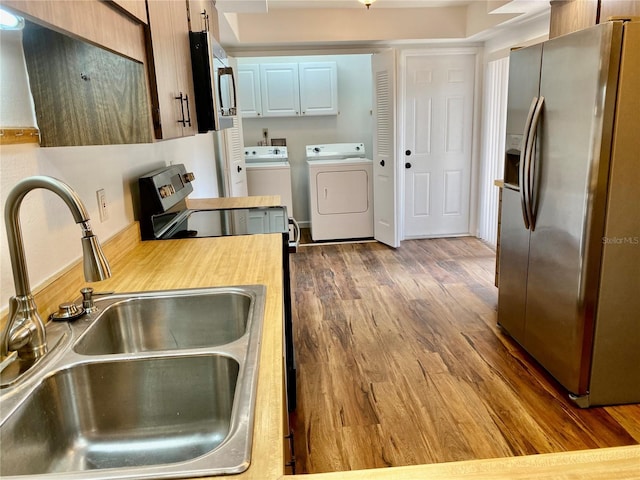 650 Woodridge Dr, Fern Park, FL 32730 - kitchen featuring appliances with stainless steel finishes, separate washer and dryer, a sink, light countertops, and wood finished floors
