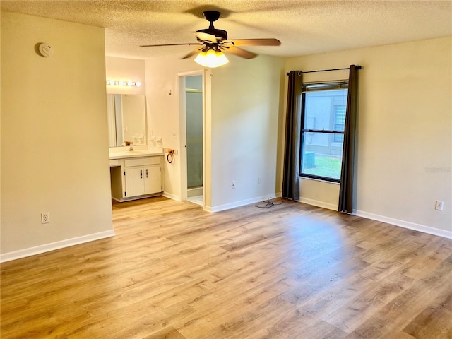 650 Woodridge Dr, Fern Park, FL 32730 - unfurnished bedroom with a textured ceiling, wood finished floors, a sink, ensuite bath, and baseboards
