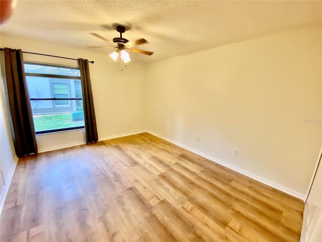 650 Woodridge Dr, Fern Park, FL 32730 - empty room with wood finished floors, a textured ceiling, a ceiling fan, and baseboards