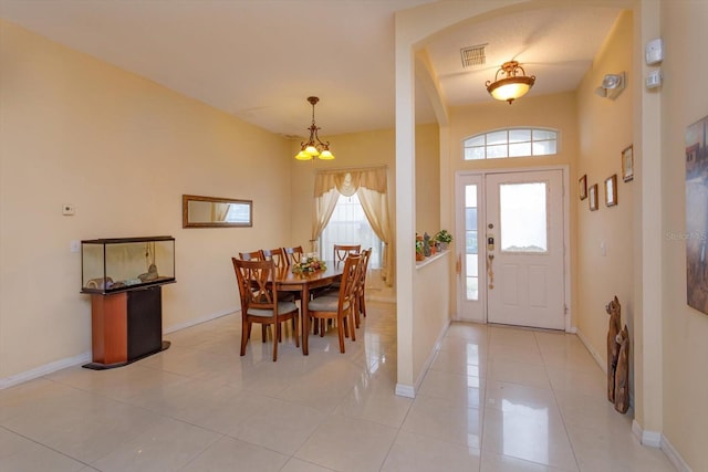 foyer entrance featuring baseboards, light tile patterned floors, and a chandelier