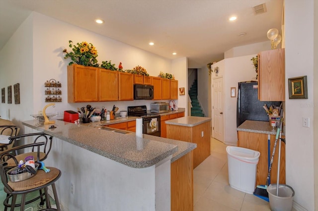 kitchen with black appliances, a center island, a peninsula, recessed lighting, and light tile patterned flooring