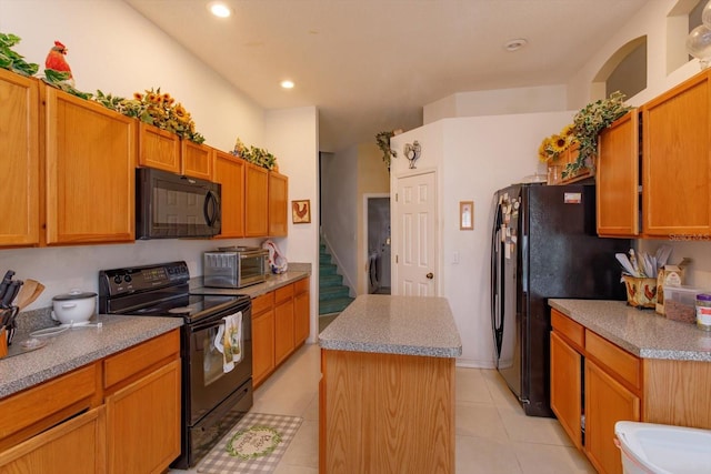 kitchen with black appliances, a center island, light tile patterned flooring, washer / dryer, and recessed lighting
