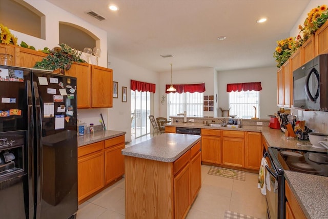 kitchen with black appliances, a peninsula, recessed lighting, light tile patterned floors, and a kitchen island