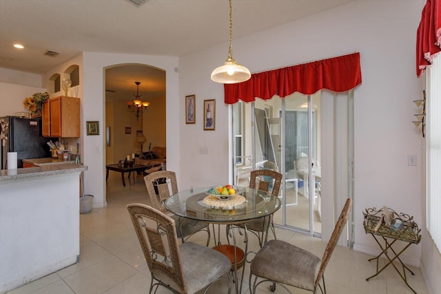 dining space with light tile patterned flooring and arched walkways