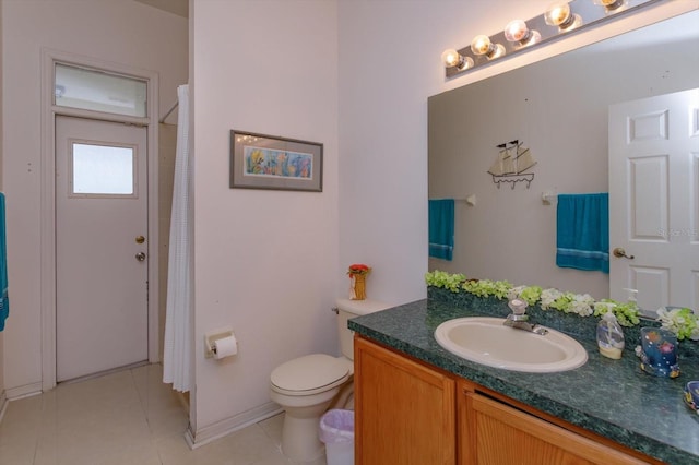 bathroom featuring vanity, tile patterned flooring, toilet, and baseboards