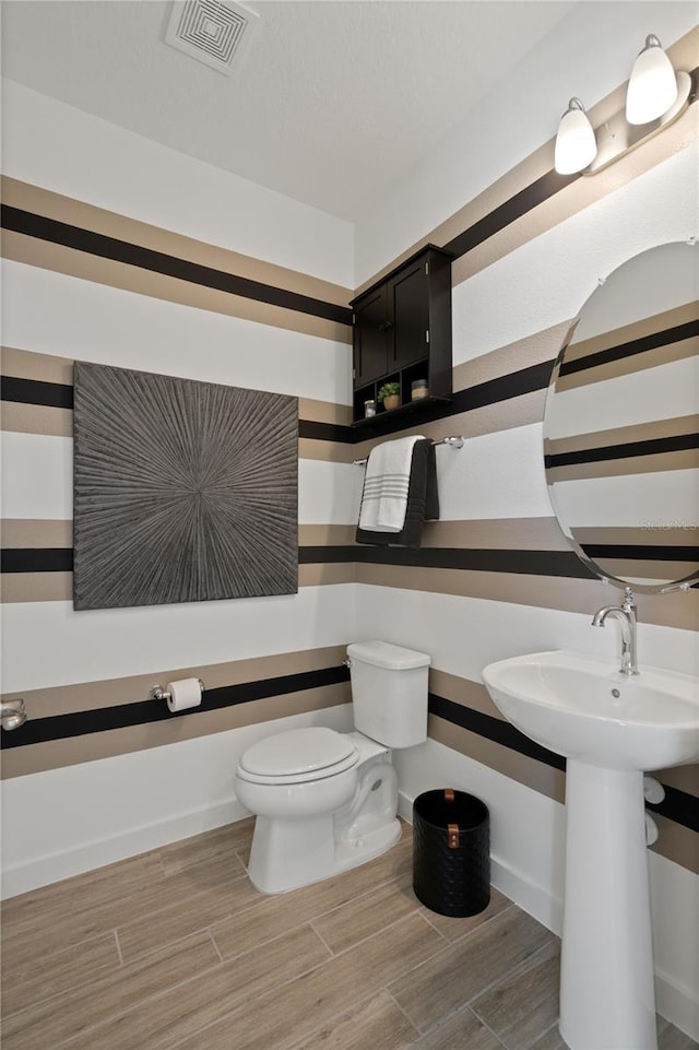 2054 Education St, Saint Cloud, FL 34771 - bathroom with wood finished floors and toilet