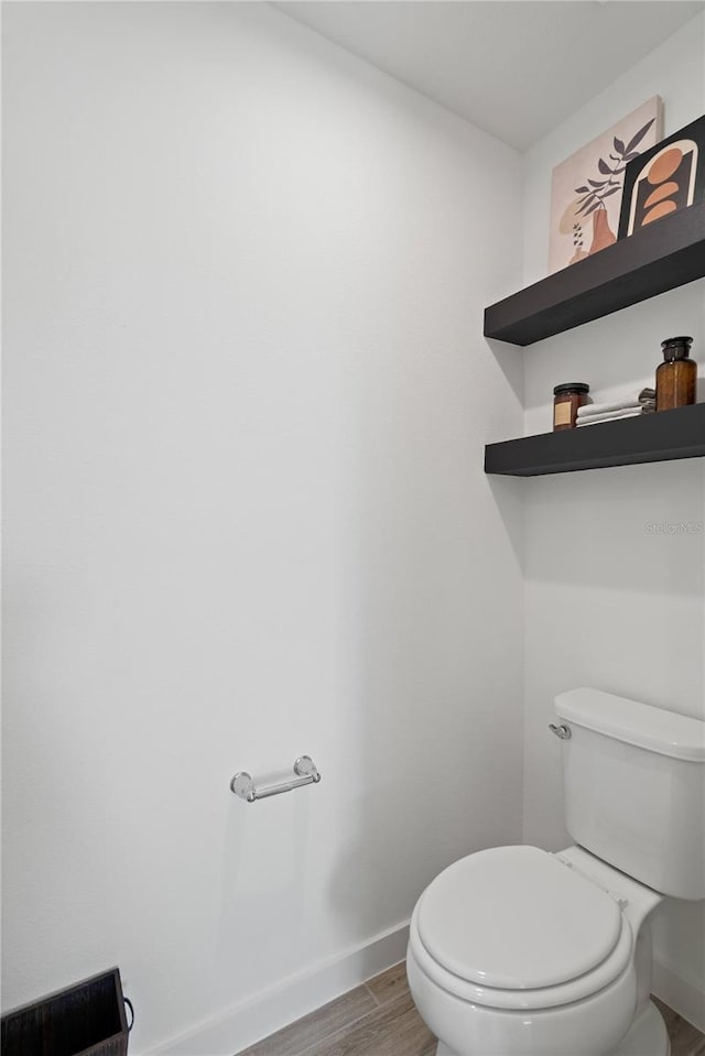 2054 Education St, Saint Cloud, FL 34771 - bathroom with baseboards, wood finished floors, and toilet