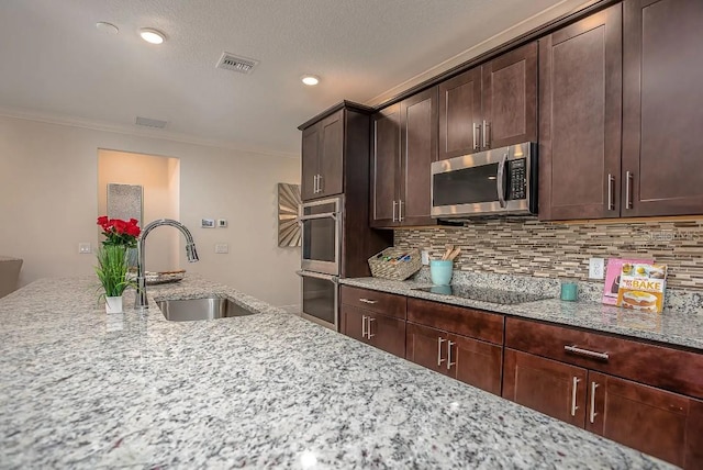 27206 Adams St, Punta Gorda, FL 33983 - kitchen featuring stainless steel appliances, a sink, light stone countertops, tasteful backsplash, and ornamental molding