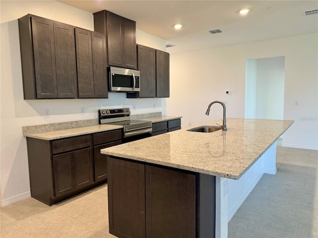 27206 Adams St, Punta Gorda, FL 33983 - kitchen featuring appliances with stainless steel finishes, a sink, light stone countertops, dark brown cabinets, and recessed lighting