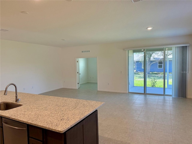 27206 Adams St, Punta Gorda, FL 33983 - kitchen featuring a sink, open floor plan, light stone countertops, dark brown cabinets, and baseboards